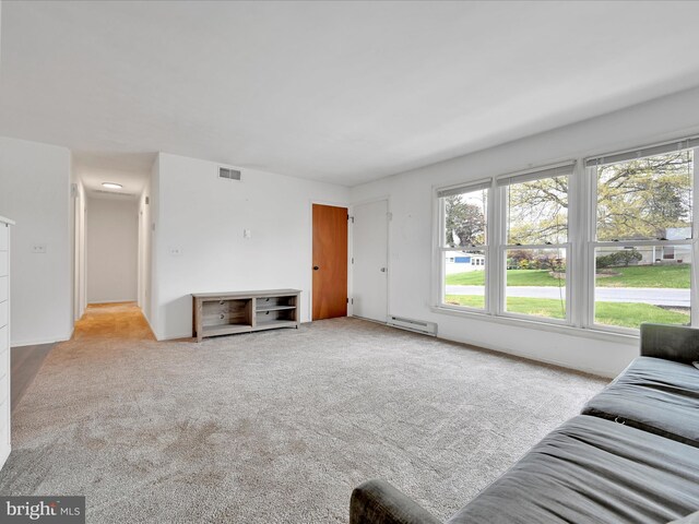 carpeted living area with visible vents and baseboard heating