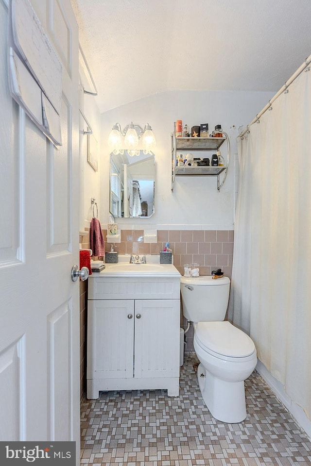 7202 Good Luck Rd, Lanham, MD 20706 - bathroom with toilet, vanity, tile walls, and a wainscoted wall