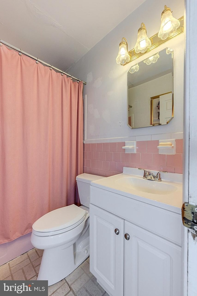 7202 Good Luck Rd, Lanham, MD 20706 - bathroom featuring tile walls, toilet, vanity, a wainscoted wall, and tile patterned floors