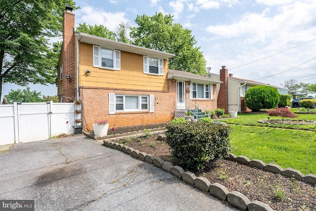 7202 Good Luck Rd, Lanham, MD 20706 - split level home featuring a chimney, brick siding, and a gate