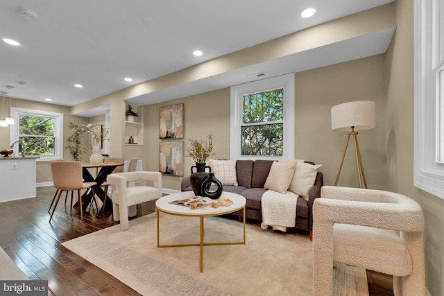 living area with built in shelves, baseboards, recessed lighting, and hardwood / wood-style floors
