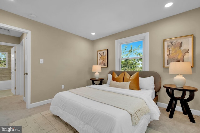 bedroom with baseboards, multiple windows, and light carpet