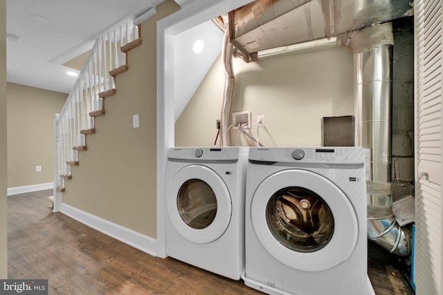 laundry room with baseboards, laundry area, wood finished floors, and washing machine and clothes dryer