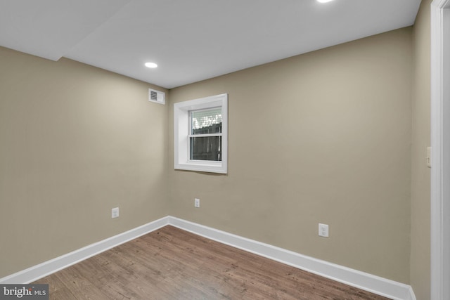 unfurnished room with baseboards, recessed lighting, wood finished floors, and visible vents
