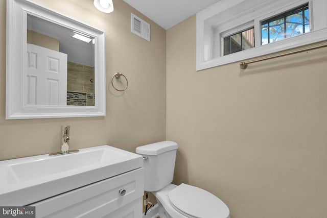 bathroom with visible vents, toilet, and vanity