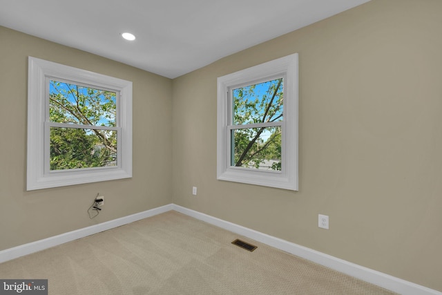 empty room with baseboards, recessed lighting, carpet floors, and visible vents