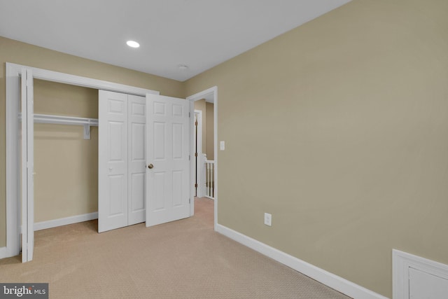 unfurnished bedroom featuring baseboards, carpet flooring, recessed lighting, and a closet