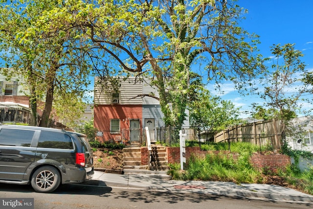 view of front of house with brick siding and fence
