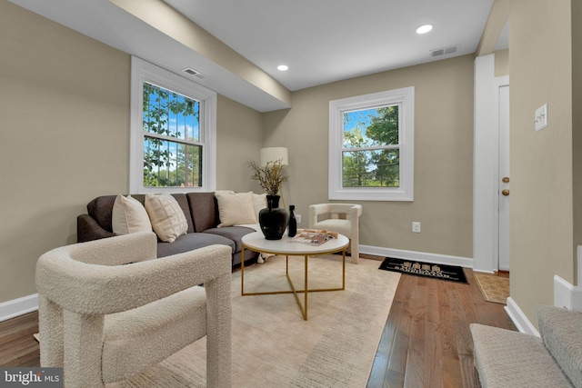 living area with recessed lighting, baseboards, visible vents, and wood finished floors