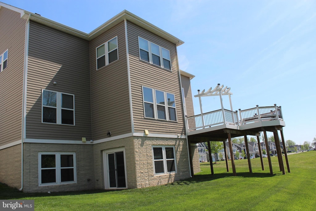 back of property featuring a yard and a deck