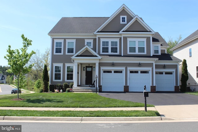 craftsman-style house with a garage, driveway, and a front yard