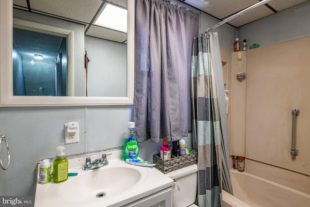 full bathroom featuring vanity, a paneled ceiling, toilet, and shower / tub combo