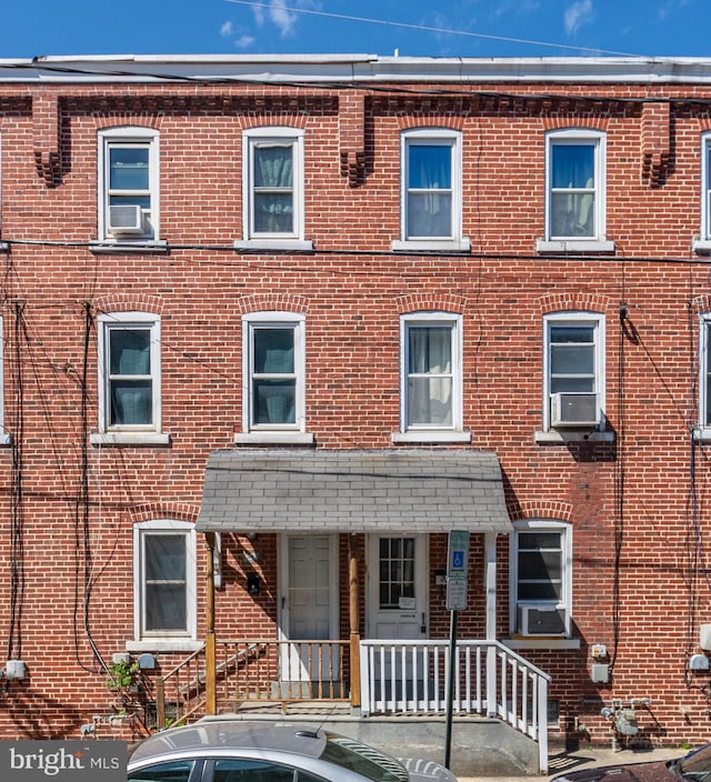 view of property featuring brick siding and cooling unit