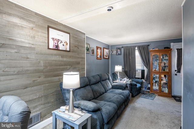 carpeted living area featuring visible vents, wood walls, a textured ceiling, and cooling unit