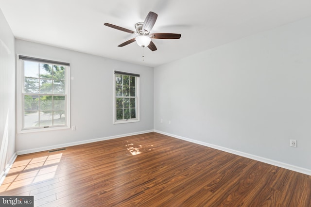 unfurnished room with a ceiling fan, baseboards, visible vents, and wood finished floors