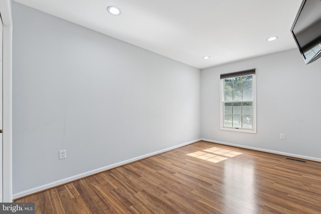 empty room featuring recessed lighting, baseboards, visible vents, and wood finished floors