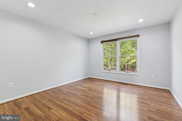 unfurnished room featuring baseboards, recessed lighting, wood finished floors, and visible vents