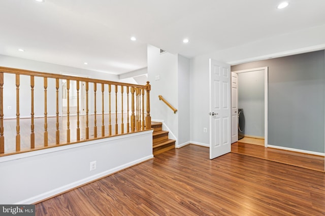 empty room with recessed lighting, baseboards, washer / dryer, and wood finished floors