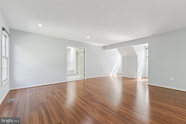 unfurnished living room featuring baseboards, wood finished floors, and visible vents