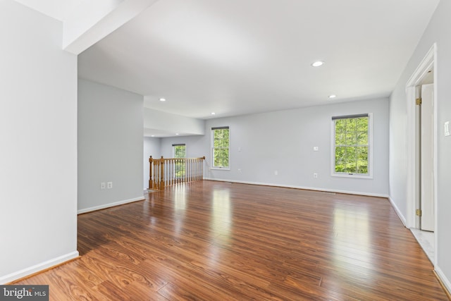 unfurnished living room with recessed lighting, baseboards, plenty of natural light, and wood finished floors