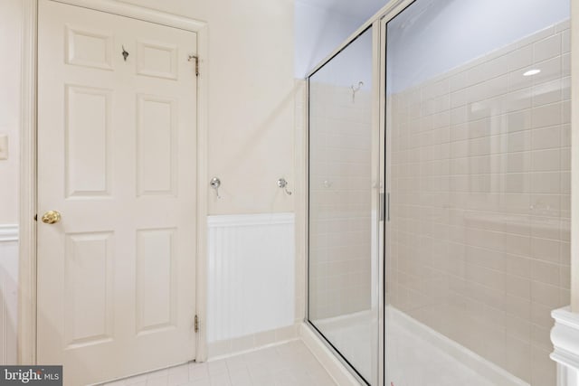 bathroom with wainscoting and a stall shower