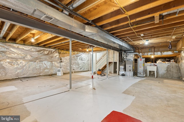 unfinished basement with a sink, water heater, heating unit, visible vents, and stairway