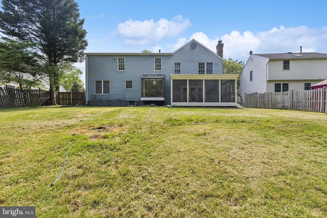 rear view of property with a fenced backyard, a yard, and a sunroom