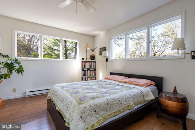 bedroom with a ceiling fan, baseboards, baseboard heating, and hardwood / wood-style flooring