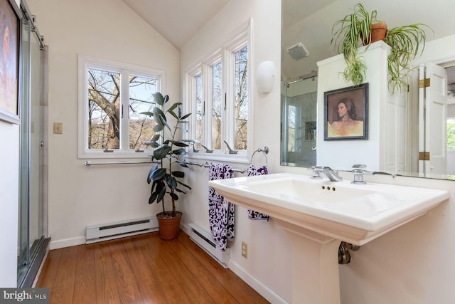 bathroom featuring vaulted ceiling, a baseboard radiator, baseboard heating, and wood finished floors
