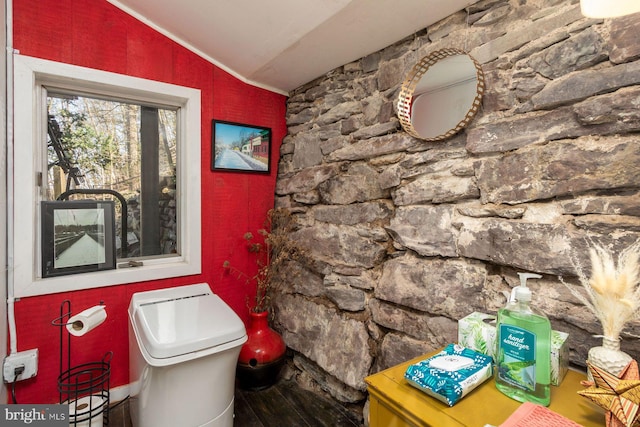 bathroom with wood finished floors, ornamental molding, lofted ceiling, and toilet