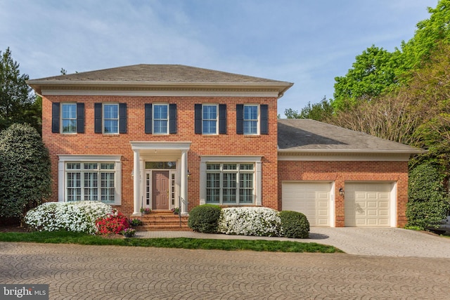 7927 Sandalfoot Dr, Potomac, MD 20854 - colonial house featuring an attached garage, brick siding, driveway, and roof with shingles