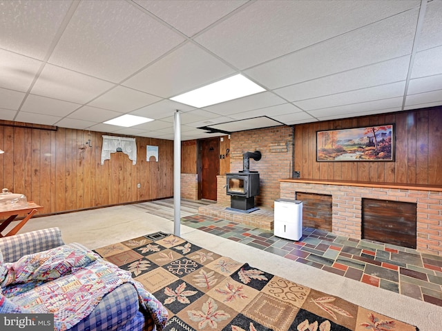 917 Houtztown Rd, Myerstown, PA 17067 - living room featuring wooden walls, a wood stove, and a drop ceiling