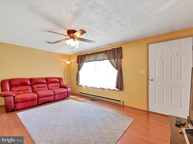 917 Houtztown Rd, Myerstown, PA 17067 - living room featuring wood finished floors, a textured ceiling, ceiling fan, and a baseboard heating unit