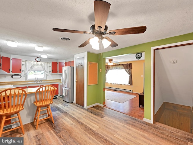 917 Houtztown Rd, Myerstown, PA 17067 - kitchen with a sink, a textured ceiling, light wood-style flooring, freestanding refrigerator, and visible vents
