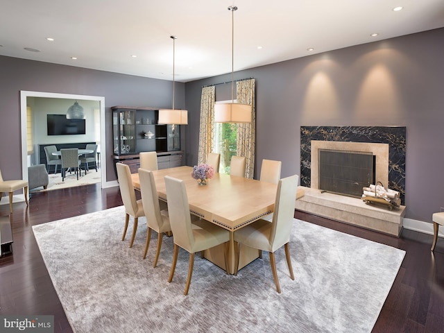 dining area featuring recessed lighting, a fireplace, and dark wood-style floors