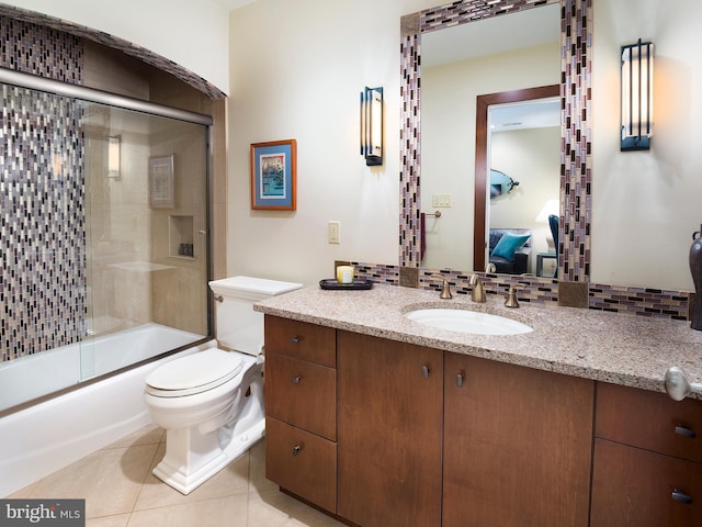 bathroom featuring tile patterned flooring, vanity, toilet, enclosed tub / shower combo, and ensuite bath