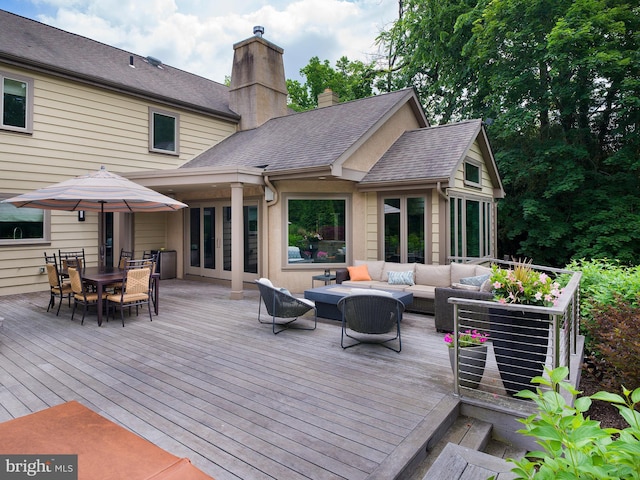 wooden terrace with outdoor dining space and outdoor lounge area