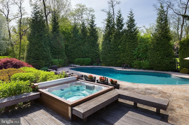 outdoor pool with a diving board, hot tub deck surround, and a wooden deck