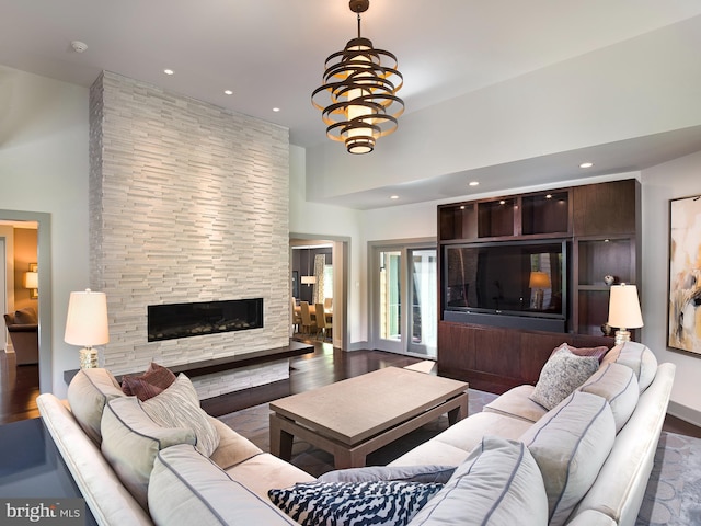 living room featuring recessed lighting, a high ceiling, dark wood-style floors, and a fireplace