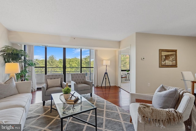 living room with baseboards, a textured ceiling, and wood finished floors