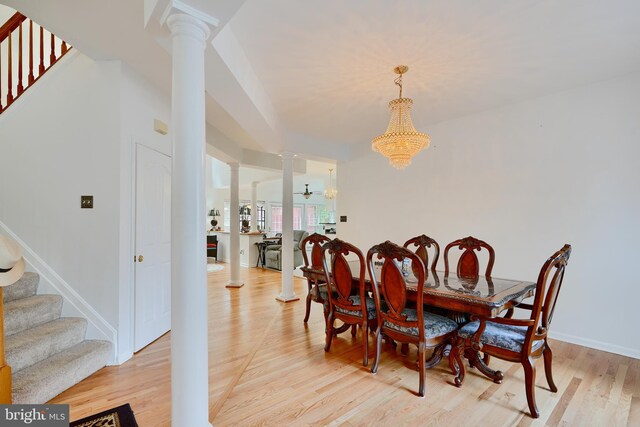 dining room with decorative columns, stairway, light wood-style floors, a chandelier, and baseboards
