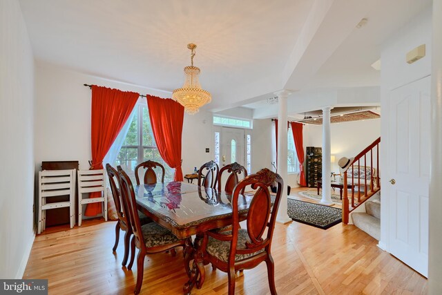 dining space featuring ornate columns, stairs, and light wood-type flooring
