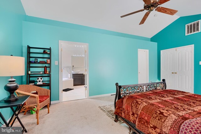carpeted bedroom with lofted ceiling, a closet, ceiling fan, ensuite bath, and baseboards