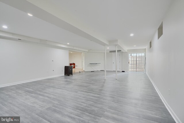 basement with baseboards, wood finished floors, and recessed lighting