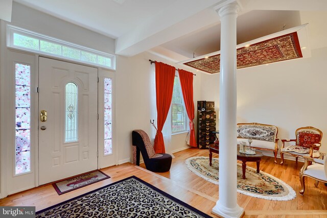 entryway featuring decorative columns, beamed ceiling, and wood finished floors