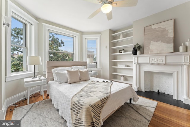 1527 Park Rd NW Unit 302, Washington, DC 20010 - bedroom with multiple windows, wood finished floors, baseboards, and a ceiling fan