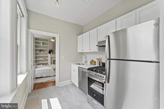 1527 Park Rd NW Unit 302, Washington, DC 20010 - kitchen featuring appliances with stainless steel finishes, a sink, under cabinet range hood, white cabinetry, and light countertops