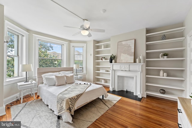 1527 Park Rd NW Unit 302, Washington, DC 20010 - bedroom featuring multiple windows, a fireplace with flush hearth, and wood finished floors