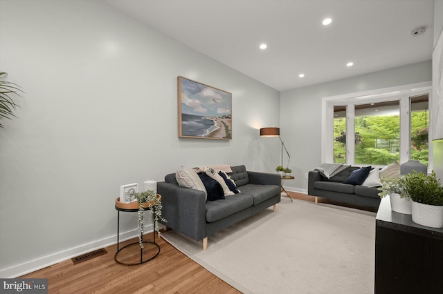 living room featuring baseboards, wood finished floors, and recessed lighting