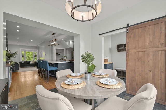 dining room with a chandelier, recessed lighting, and a barn door